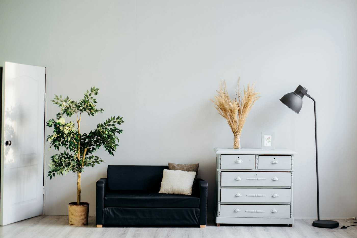 Rincón de living con sillón, cómoda y planta